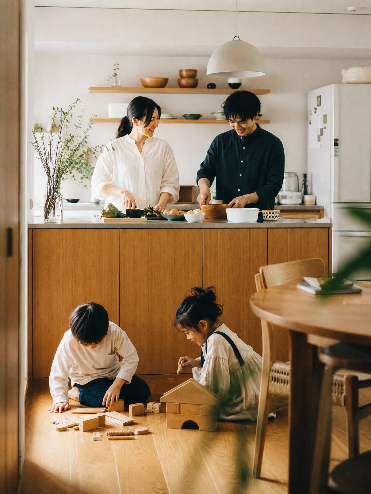 Family cooking together in a bright kitchen while the kids play on the floor
