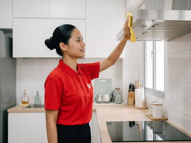 An Expert wiping the front of a stainless range hood