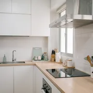 A kitchen with a sink, a hob and a range hood